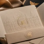 Faire part mariage château : pochette ciselée ouverte, dorure à chaud et vernis UV brillant
