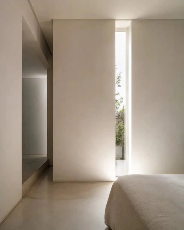Fenêtre meurtrière verticale dans une chambre lumineuse et intime